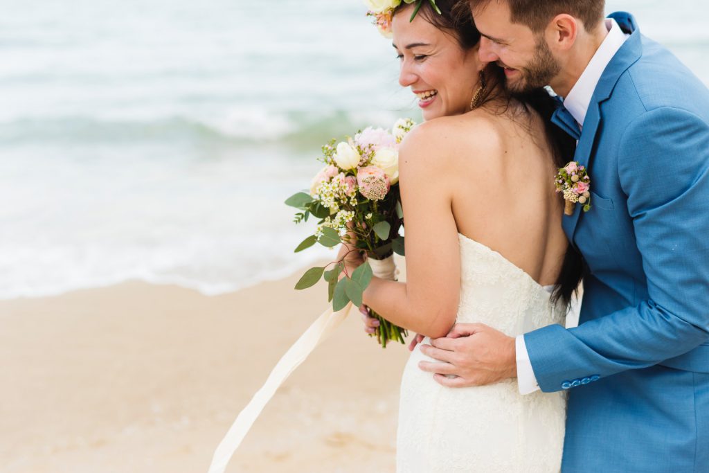 Marido abrazando a su mujer a orillas del mar