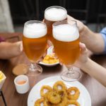 Amigos bebiendo cerveza y comiendo en un bar.